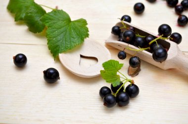 black currant with leaves on wooden background