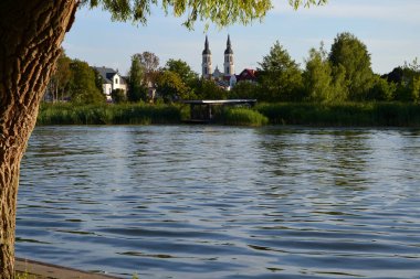 Şehir kilisesinde mimari, nehrin arka planındaki ağaçların arasında.