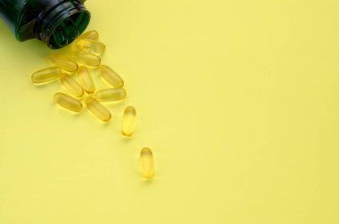 Omega 3 kapsülleri şişeden ve alandan metin için dökülür 
