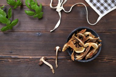 ingredients dried forest mushrooms in a bowl on a wooden table, flat lay