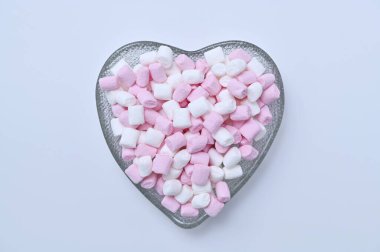 Kalp şeklindeki bir kasede küçük şekerlemeler.