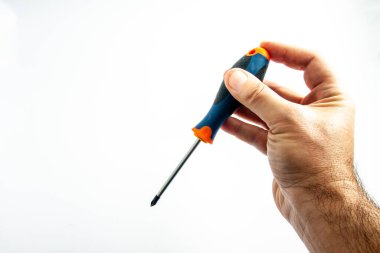 Elinde tornavidayla çalışan bir işçinin eli, bir işi yapmaya hazırlanıyor, bir vidayı düzüyor ya da söküyor.