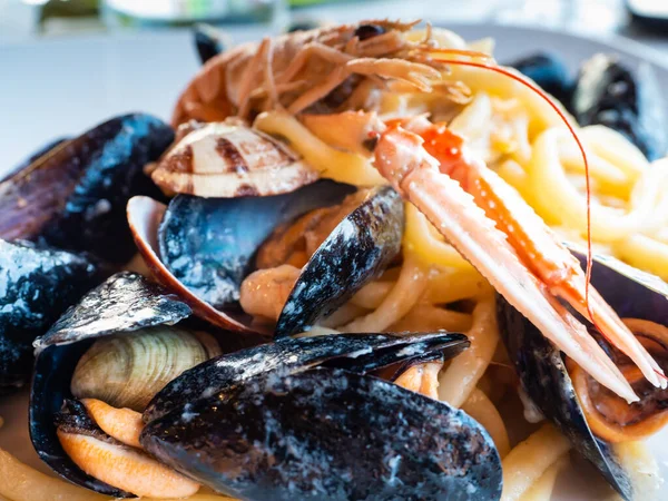 在一个温和的春晚 在地中海的一家意大利餐馆里 有一盘意大利面和新鲜的鱼混合在一起 贝类和贻贝 — 图库照片