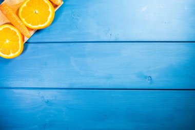 Geniş yatay mavi alanda, taze meyve, portakal ve havuç bileşiminin üst görünümü ve yaz atmosferi