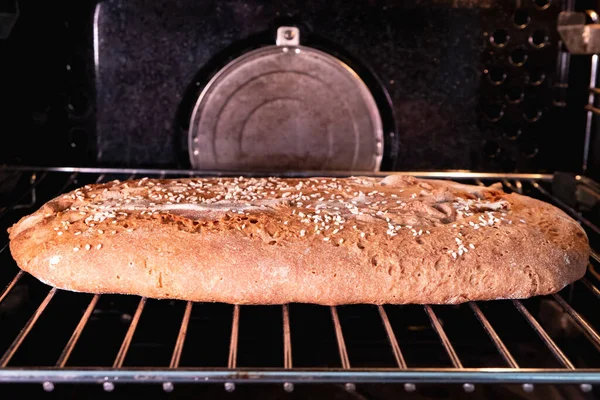 家庭の台所の電気オーブンでゴマで焼いたパン — ストック写真