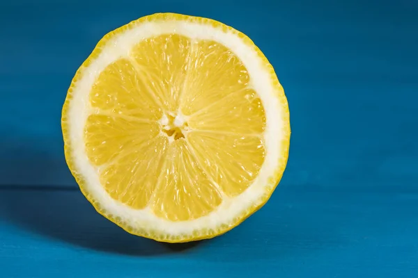 Fresh lemon cut in the foreground on blue background in summer atmosphere