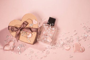 Kravat kartonundan yapılmış kalp şeklinde bir hediye kutusu. Parfüm şişesi, dekoratif kalpler ve yapay elmaslar. Sevgililer Günü hediyesi, düğün hediyesi. Şenlikli arkaplan.