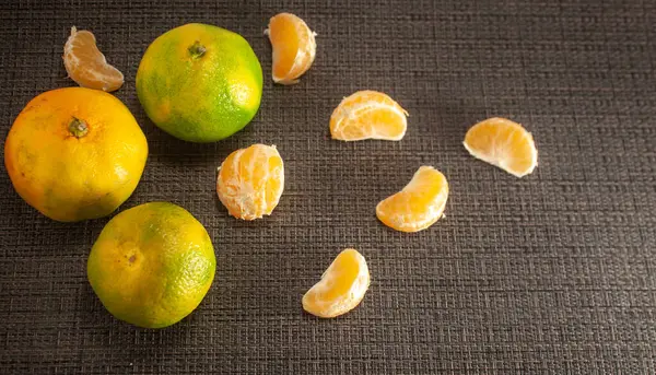 黑色的背景上有新鲜的橘子皮 附近是甘露片 柑橘类水果 天然健康食品 后续行动 — 图库照片