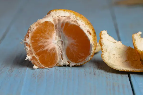 Geschälte Halbfrische Reife Mandarine Auf Blauem Holzgrund Nahaufnahme — Stockfoto