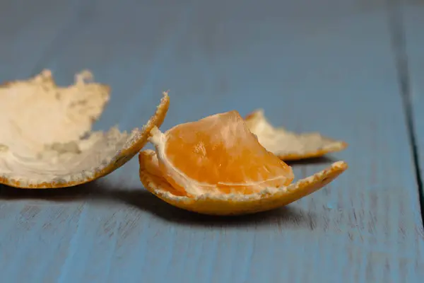 Eine Gebissene Mandarinenscheibe Auf Blauem Holzgrund Nahaufnahme — Stockfoto