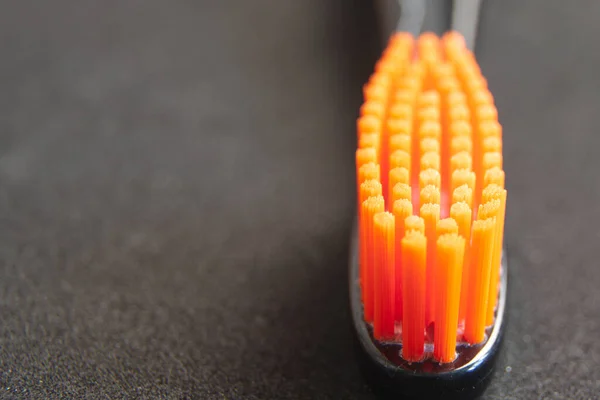 Cepillo Dientes Negro Con Cerdas Naranjas Cerca Sobre Fondo Negro — Foto de Stock