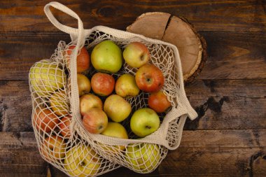 Eko torbasıyla düz kompozisyon ve kütük. Elmalar pamuk torbada. Sıfır atık, plastiksiz, yeniden kullanılabilir konsept