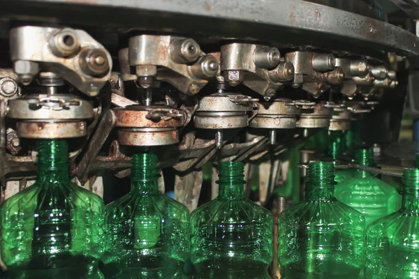 Green plastic bottles in a conveyor. The concept of producing clean water and beverages