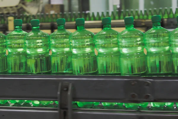 Conveyer belt with green plastic bottles for beverages. Perspective view. concept of producing clean bottled water