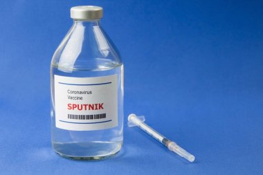 Krasnodar, Rusya - 12 Ocak 2021: Covid-19 'dan bir şişe Sputnik aşısı ve mavi arka planda bir şırınga