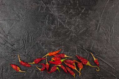 Kuru kırmızı kırmızı kırmızı biber siyah arka planda yatar. Metin için üst görünüm ve boşluk