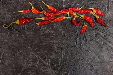 Siyah arka planda kırmızı kırmızı biber var. Metin için üst görünüm ve yer