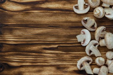 Yanmış ahşap bir tahtanın üzerinde taze kesilmiş mantarlar. Metin için boşluk