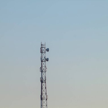 Şehir dışında kirli mavi gökyüzüne karşı bir baz istasyonu.