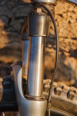 Üzerinde kum olan bir dağ bisikleti çatalının aşınmış ayakları. Yakın plan.