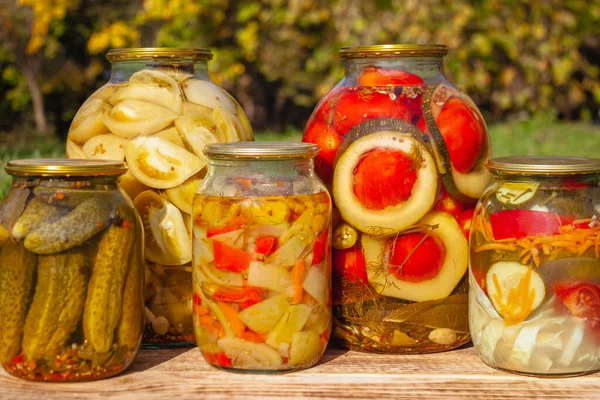 Homemade pickles in cans, rustic food and snacks, canned cucumbers, tomatoes, eggplants and cabbage of the autumn harvest. Traditional Russian snack