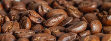 Makro bir fotoğrafta taze kavrulmuş kahve çekirdekleri. Yan görüş. Arkaplan resmi