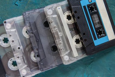 Koyu mavi beton arka planda birkaç ses kaseti var. Üst Manzara. Metin için yer aç. Yakın plan.