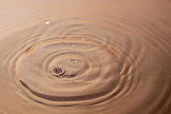 Clear water in shallow sea water. Circles spread out on its surface. And you can see it under the water. Background image