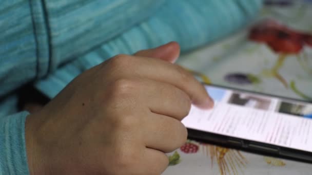 女孩翻阅着放在桌上的智能手机屏幕上的信息 — 图库视频影像