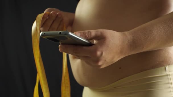 Een Size Vrouw Die Smartphone Gebruikt Met Mesaurement Tape Hand — Stockvideo