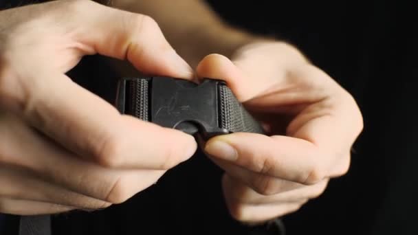 Man Hands Unfasten Black Plastic Fastener His Belt Black Background — Stock Video