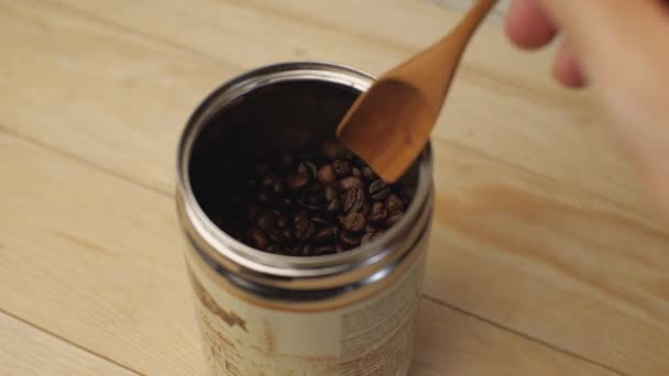 用木勺把咖啡豆从罐子里捞出来 轻型木制背景 后续行动 — 图库视频影像