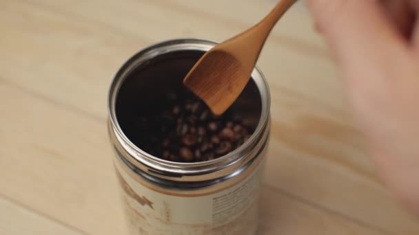 Ręka Mężczyzny Wyjmuje Ziarna Kawy Słoika Drewnianą Łyżeczką Wylewa Powrotem — Wideo stockowe
