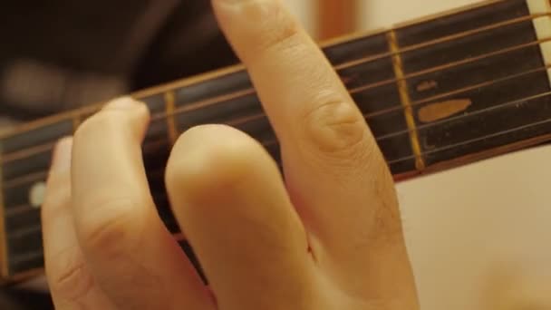 男性的手指在一把旧的破烂不堪的音响吉他上弹奏着竖琴 — 图库视频影像