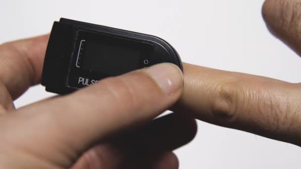 人間の指に装着された黒い電子パルス酸素濃度計パルス酸素と血液酸素の迅速な診断 — ストック動画