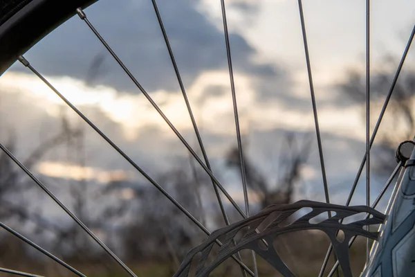透过山地车的轮毂 朦胧的落日的天空 健康生活方式概念 — 图库照片