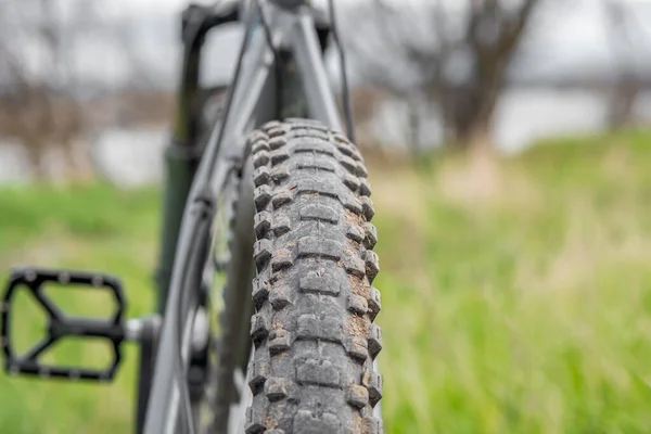 一辆满载肮脏轮胎的山地自行车靠在绿草的衬托下 后视镜有选择的重点 健康生活方式概念 — 图库照片