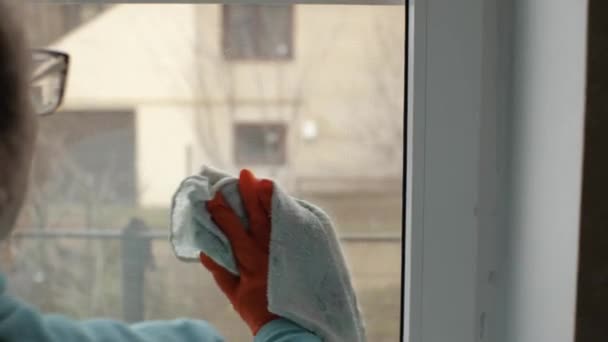 Ein Mädchen Orangefarbenen Handschuhen Reibt Das Glas Eines Plastikfensters Mit — Stockvideo