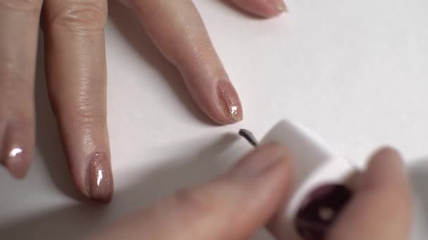 老年妇女用刷子在左手的钉子上涂指甲油 白色背景 手指上的特写身体护理概念 — 图库视频影像