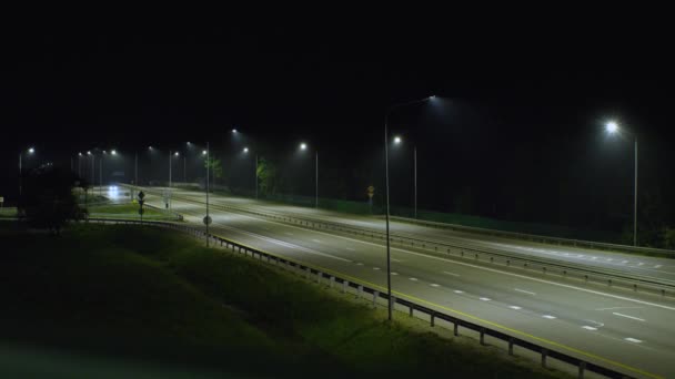Nocna Podmiejska Autostrada Jednym Przejeżdżającym Samochodem Droga Jest Oświetlona Latarniami — Wideo stockowe