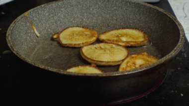 Spatulaların yardımıyla kadınların elleri krepleri kreplerden temizler. Ev mutfağında yakın plan krep yapma süreci.