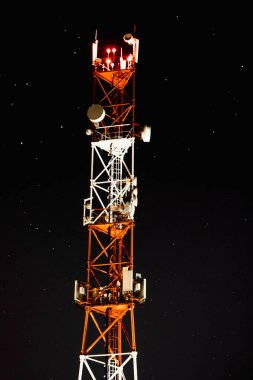 Yıldızlı gökyüzünün arka planında antenleri olan telekomünikasyon kulesi. Gece mobil iletişim merkezi.