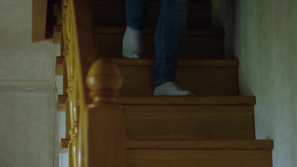 ジーンズと白い靴下の足は木製の家の階段を降ります カメラは足を追う — ストック動画