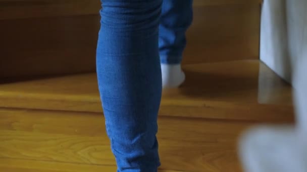穿着牛仔裤和白袜的脚走在木制楼梯的台阶上 摄像机跟在脚后面 — 图库视频影像