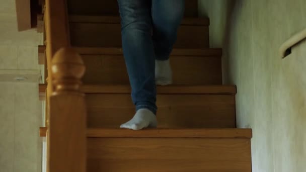 一个穿着牛仔裤和白袜的女人走在木屋里的一个木制楼梯的台阶上 摄像机跟在脚后面 — 图库视频影像