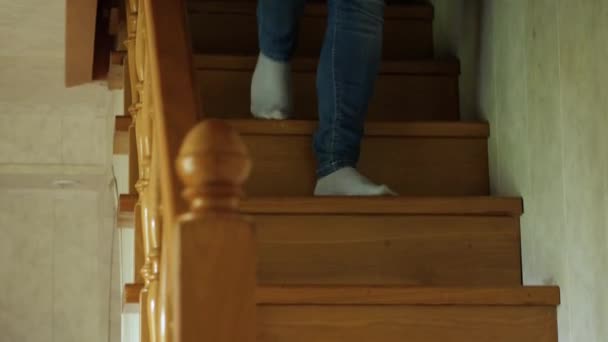 一个穿着蓝色牛仔裤和白色袜子的女人的脚走在村舍的木制楼梯的台阶上 摄像机跟在脚后面 — 图库视频影像