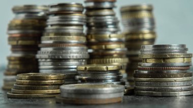 Farklı ülkelerden gelen paralar siyah arka planda farklı yüksekliklerde yığılmıştır. Seçici odaklanma. Finans ve tasarruf kavramı. Yakın plan.