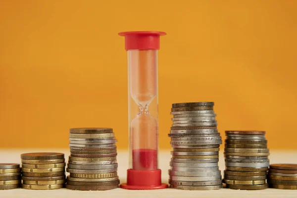 Red Hourglass Stands Row Stacks Coins Concept Time Money Close — Stock Photo, Image
