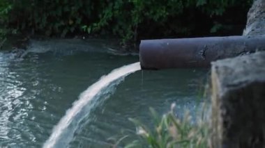 Borudan nehre kirli kokulu su akıtıyor. Rusya 'da çevre kirliliği. Kamera yukarıdan aşağıya hareket ediyor