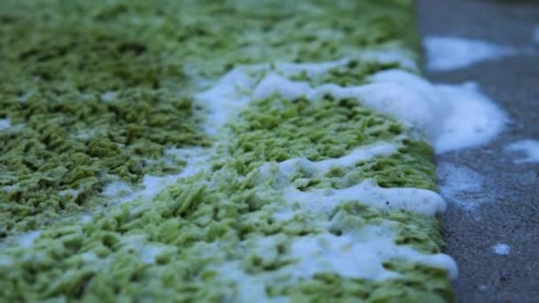 用白色泡沫湿透绿色地毯 摄像机从右移到左移 清洁的概念 — 图库视频影像